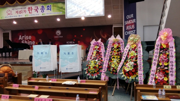 Not sure about these flower arrangements, but there were several at the front of the auditorium (2 of the voting booths are on the left).